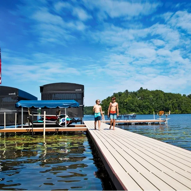 Children walking on a dock beside a ShoreStation boat lift
